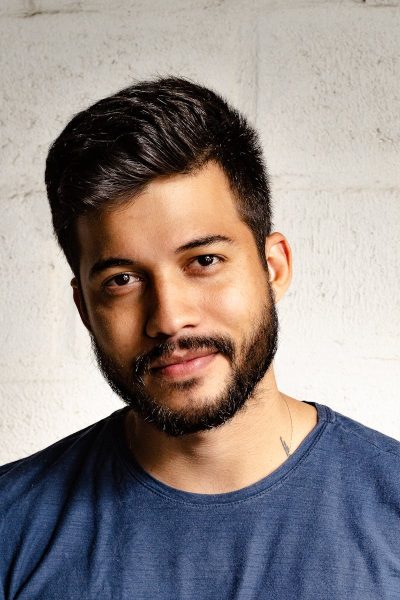 Close-up portrait of a handsome man with a beard in casual attire, smiling warmly.